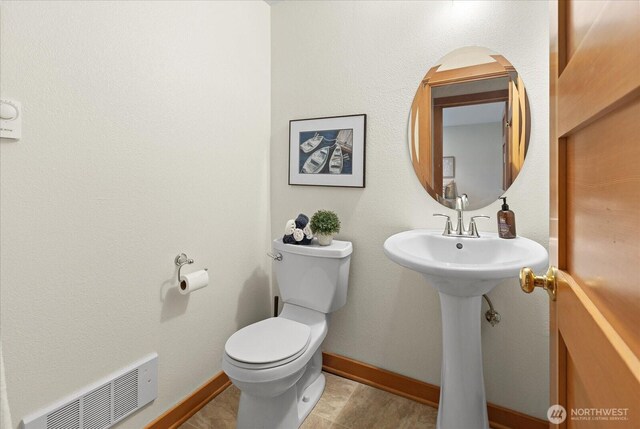 bathroom featuring baseboards, visible vents, and toilet