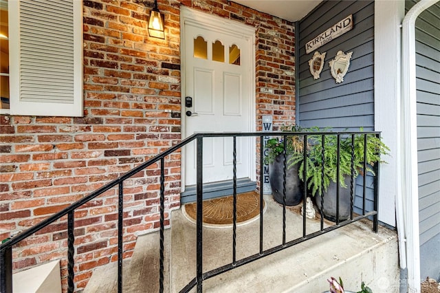 view of exterior entry featuring brick siding