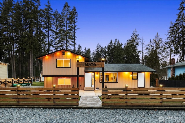 view of front of house featuring a fenced front yard, a shingled roof, and board and batten siding