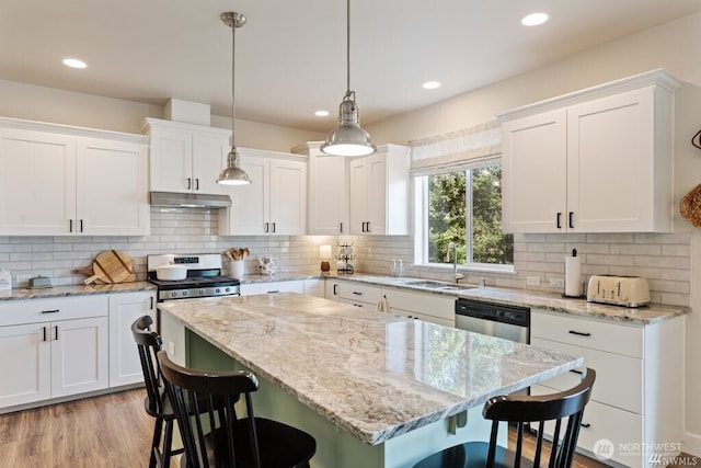 kitchen with sink, white cabinetry, and a kitchen bar