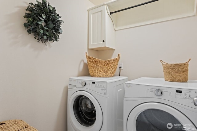 washroom with washer and dryer and cabinets