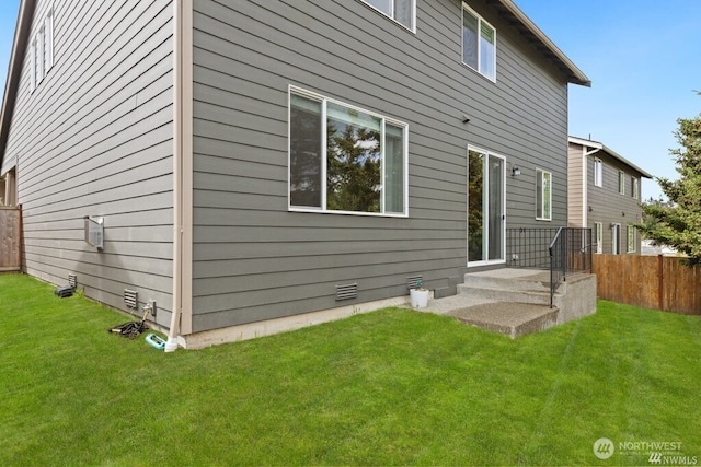 rear view of property featuring a lawn