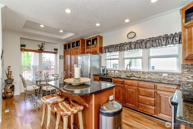 kitchen featuring a center island, sink, appliances with stainless steel finishes, a kitchen bar, and decorative backsplash