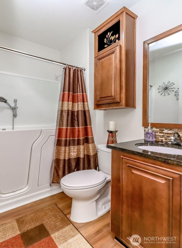 full bathroom featuring shower / bath combo, toilet, vanity, and wood-type flooring