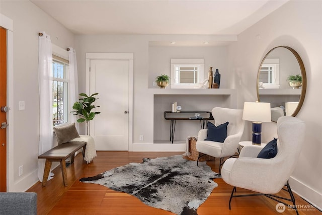 living area featuring baseboards and wood finished floors