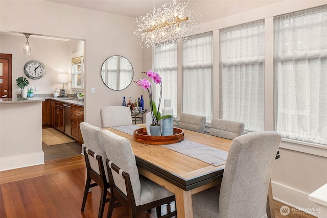 dining area featuring wood finished floors and an inviting chandelier