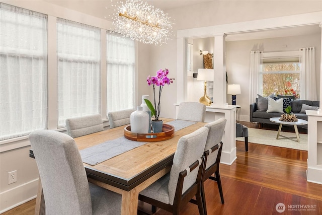 dining room with baseboards, wood finished floors, and an inviting chandelier