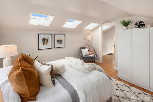 bedroom with light wood-type flooring and lofted ceiling