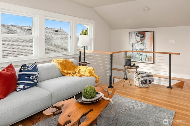 living area with vaulted ceiling and wood finished floors