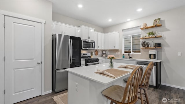 kitchen with open shelves, light countertops, appliances with stainless steel finishes, white cabinetry, and a kitchen island