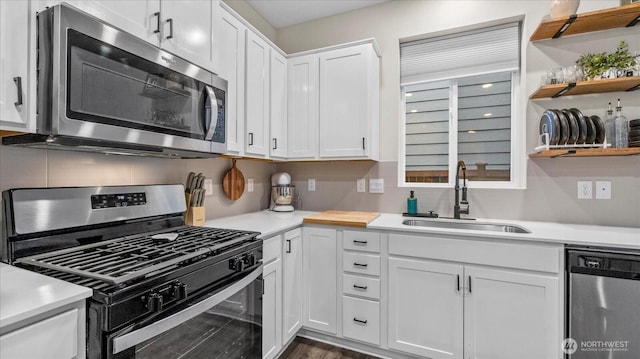 kitchen featuring white cabinetry, appliances with stainless steel finishes, light countertops, and a sink