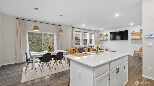 kitchen featuring white cabinets, pendant lighting, light countertops, and open floor plan