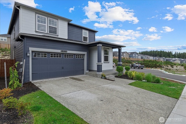 traditional home with a garage, a residential view, and concrete driveway