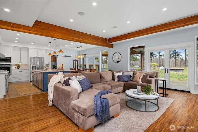 living area featuring french doors, light wood finished floors, beamed ceiling, and recessed lighting