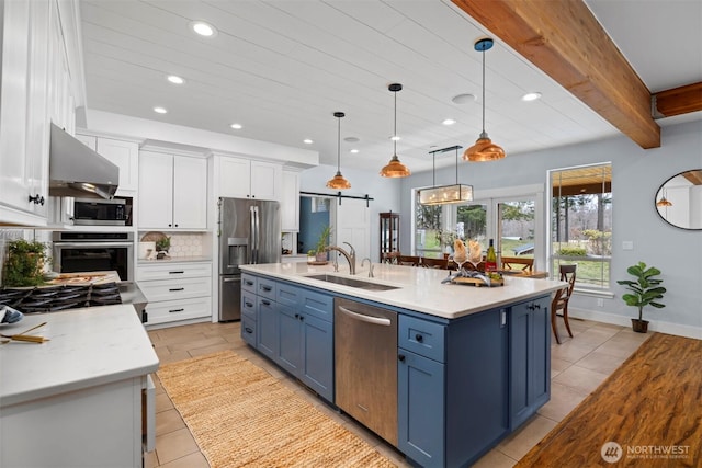 kitchen featuring a spacious island, a sink, hanging light fixtures, blue cabinetry, and appliances with stainless steel finishes