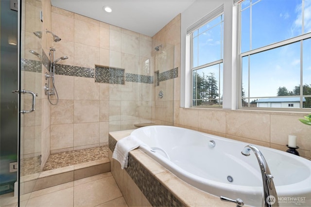 bathroom featuring a healthy amount of sunlight, a garden tub, tile patterned flooring, and a stall shower