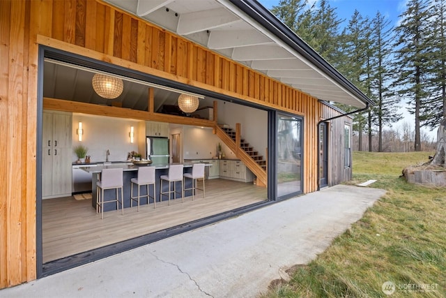 exterior space featuring stairway, an outdoor bar, and a deck