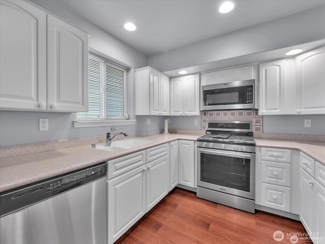 kitchen featuring sink, stainless steel appliances, and white cabinetry