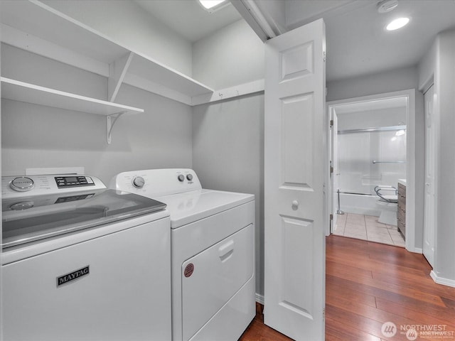 laundry room featuring wood-type flooring and washer and clothes dryer