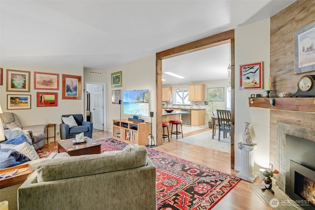 living room featuring a fireplace and light wood-type flooring