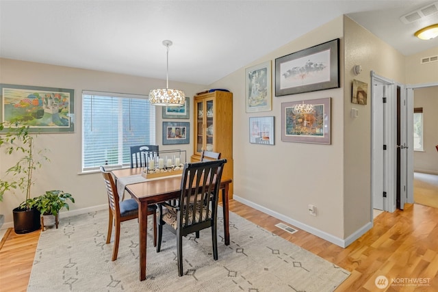 dining space featuring vaulted ceiling and hardwood / wood-style floors