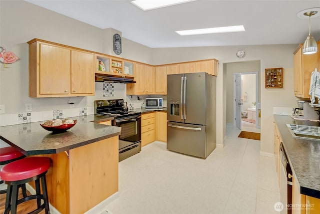 kitchen featuring kitchen peninsula, stainless steel appliances, decorative light fixtures, light brown cabinets, and a kitchen breakfast bar