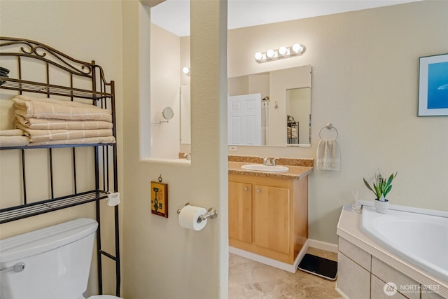 bathroom with vanity, a washtub, and toilet