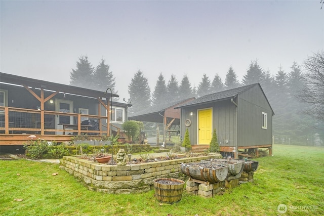 rear view of house featuring a lawn and a wooden deck