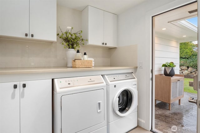 washroom featuring independent washer and dryer and cabinet space