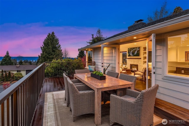 deck at dusk featuring outdoor dining space