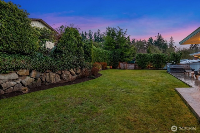 yard at dusk featuring a patio area