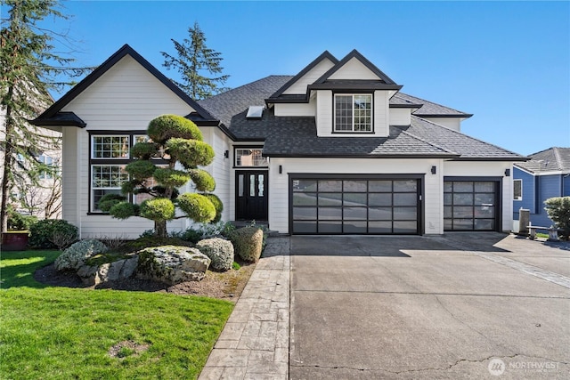 view of front facade with a garage, concrete driveway, a front lawn, and roof with shingles