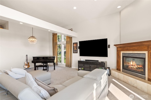 living area with carpet floors, a chandelier, a glass covered fireplace, and recessed lighting