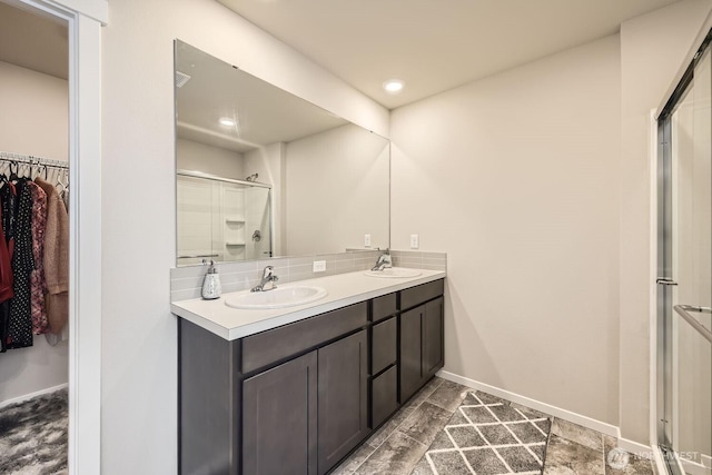 bathroom featuring tasteful backsplash, vanity, and walk in shower