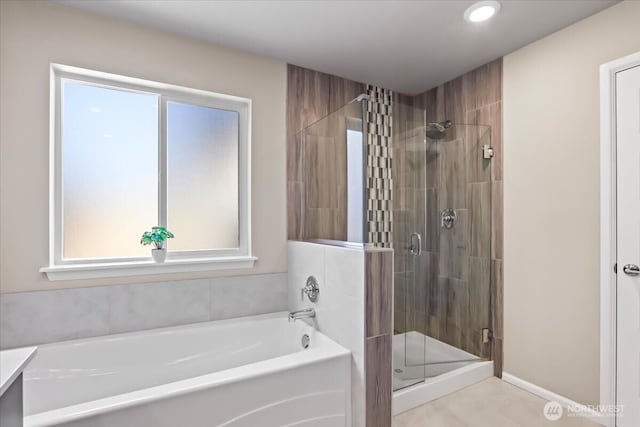 full bathroom featuring a stall shower, a bath, and baseboards