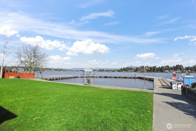 dock area featuring a water view and a lawn