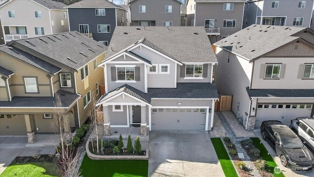 view of front of house featuring a garage, a residential view, roof with shingles, and driveway