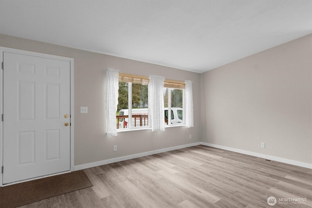 interior space with light wood-type flooring, visible vents, and baseboards