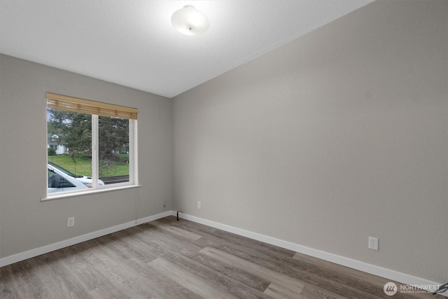 spare room with light wood-style flooring and baseboards