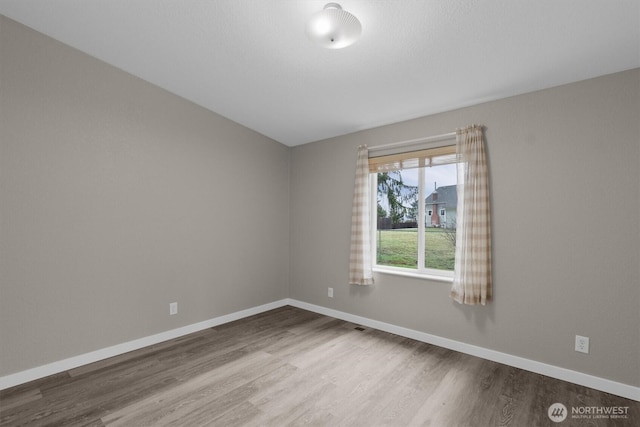 unfurnished room featuring baseboards and wood finished floors