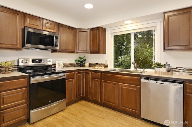 kitchen with sink, light wood-type flooring, and stainless steel appliances