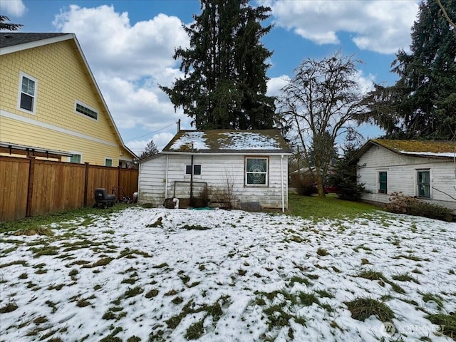 snow covered back of property with fence