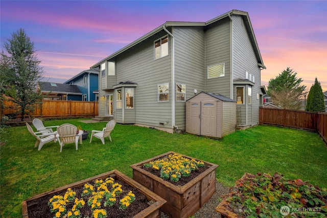 back house at dusk featuring a yard and a storage shed