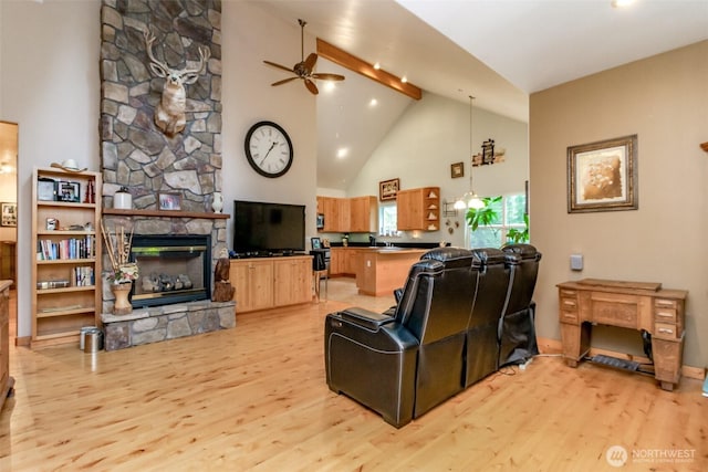 living area with high vaulted ceiling, beam ceiling, light wood-style flooring, ceiling fan, and a stone fireplace