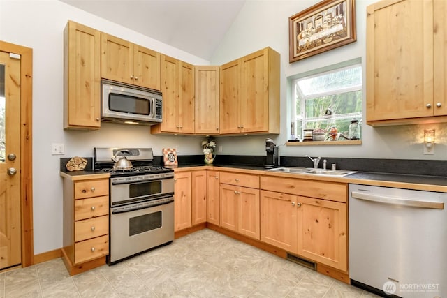 kitchen with a sink, stainless steel appliances, visible vents, and light brown cabinetry