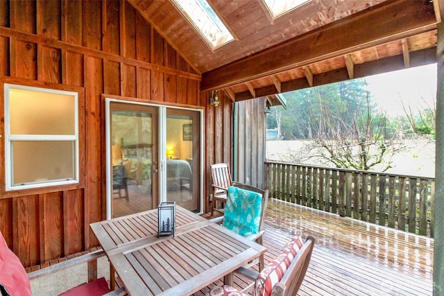 sunroom / solarium featuring lofted ceiling with skylight