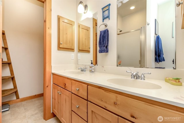 full bath featuring tile patterned floors, double vanity, a stall shower, and a sink