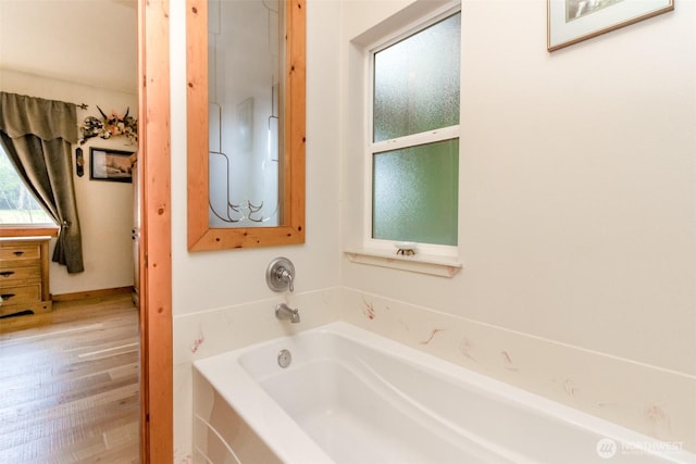 full bath with a garden tub and wood finished floors