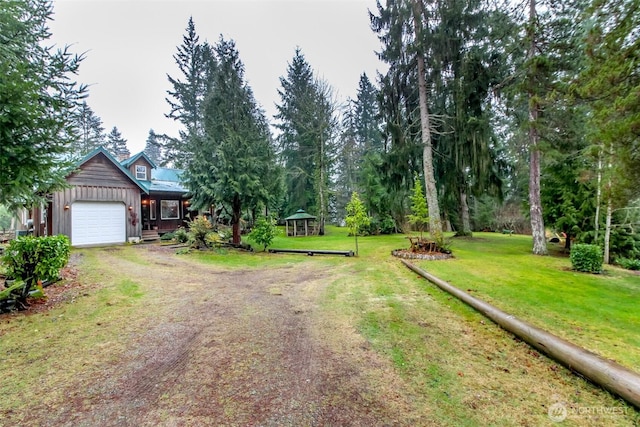 view of yard with a garage and driveway