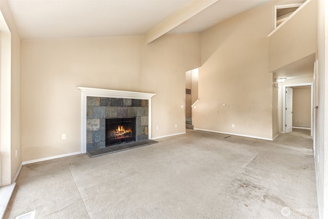 unfurnished living room featuring baseboards, a tiled fireplace, carpet, high vaulted ceiling, and beam ceiling